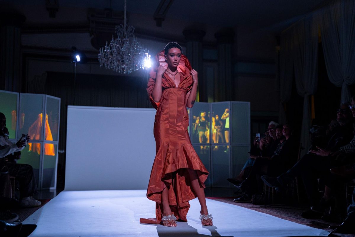 A model wearing a garment designed by Ajovang poses at the end of the runway during the Create vs. Consume runway run by the Chicago Fashion Coalition at Stan Mansion in Logan Square on Friday, Oct. 11, 2024.