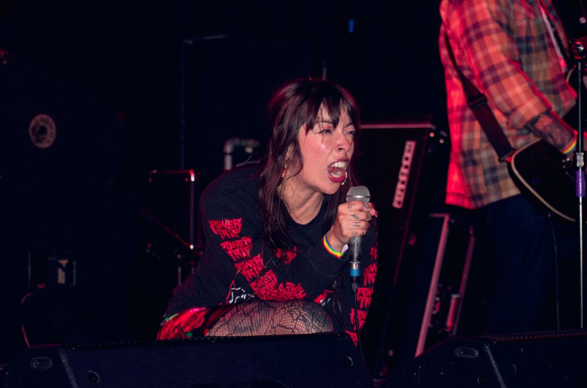 Karly Soto screams into the mic as she kneels down and looks at the crowd at Beat Kitchen on Thursday, Oct. 10, 2024.