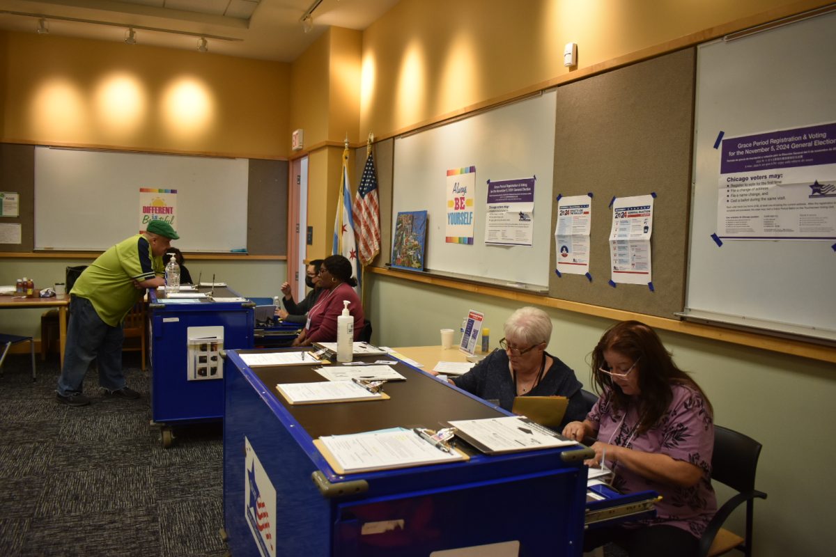 Polling site workers looking through documents and assisting voters at Archer Heights Public Library on Wednesday, Oct. 23, 2024.