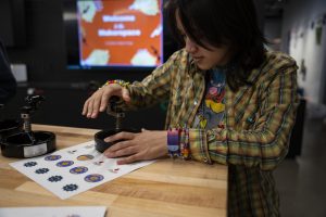 First-year traditional animation major Veronica Wirth makes voting buttons for the upcoming election day at the student center on Wednesday, Oct. 16, 2024.