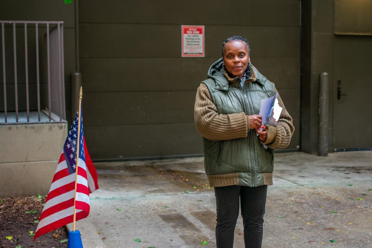 Shola Kehinde, a volunteer for Alderman Riley, poses for a photo outside a polling center on Tuesday, Nov. 5, 2024.