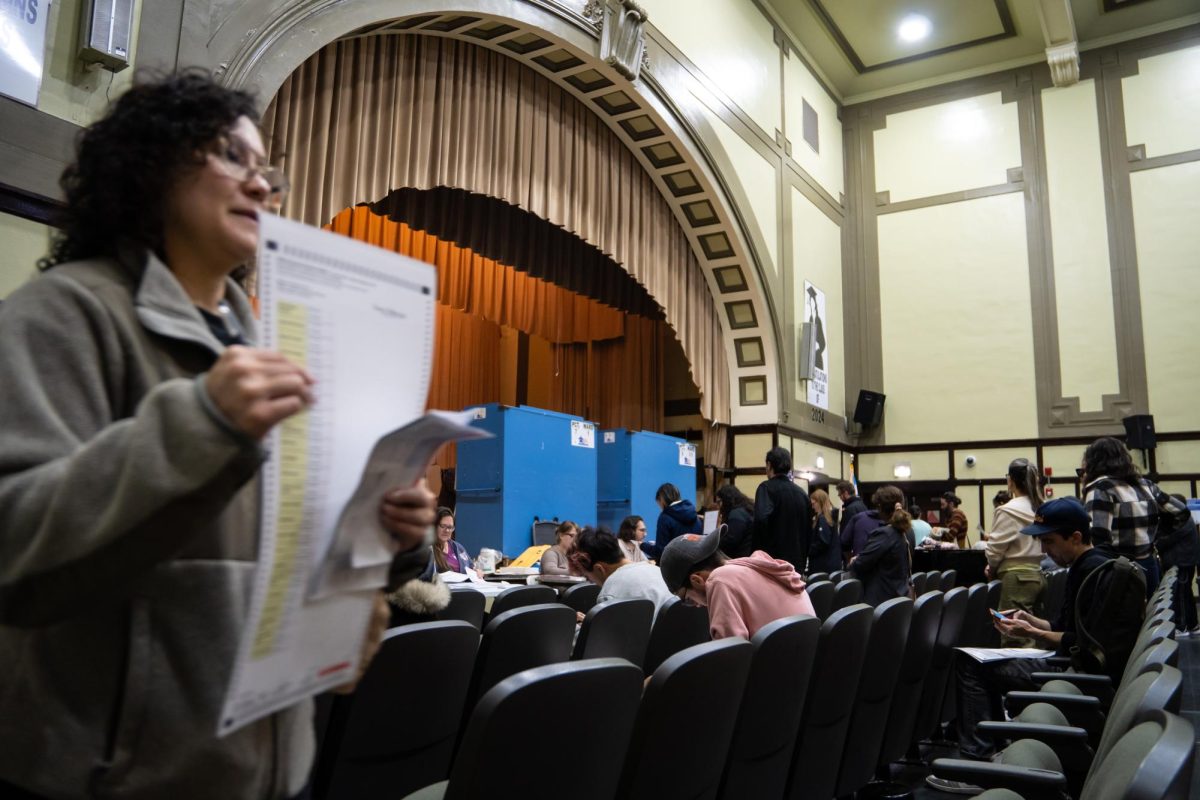 A registered voter walks to turn in their filled-out ballot inside of Charles R. Darwin Public School, the election day polling site in the Logan Square neighborhood in Chicago on Tuesday, Nov. 5, 2024.