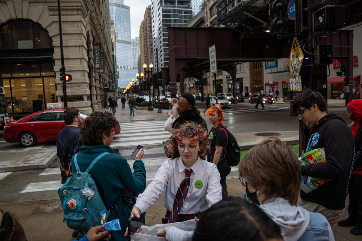 Teddi Karnes, Columbia Votes! voter genius sophomore film and television major, hands snacks to participants walking to the Chicago supersite polling location on Tuesday, Nov. 5, 2024. 