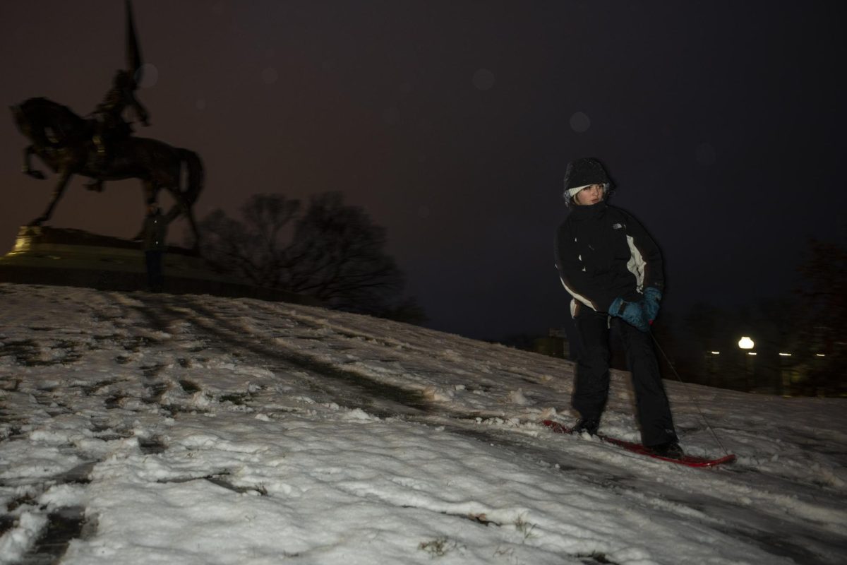 First-year Jones College Prep Student Lucas Casey snowboards down the hill of the General John Logan Memorial Statue located in Grant Park during Chicago's first winter snow day on Thursday, Nov. 21, 2024. 