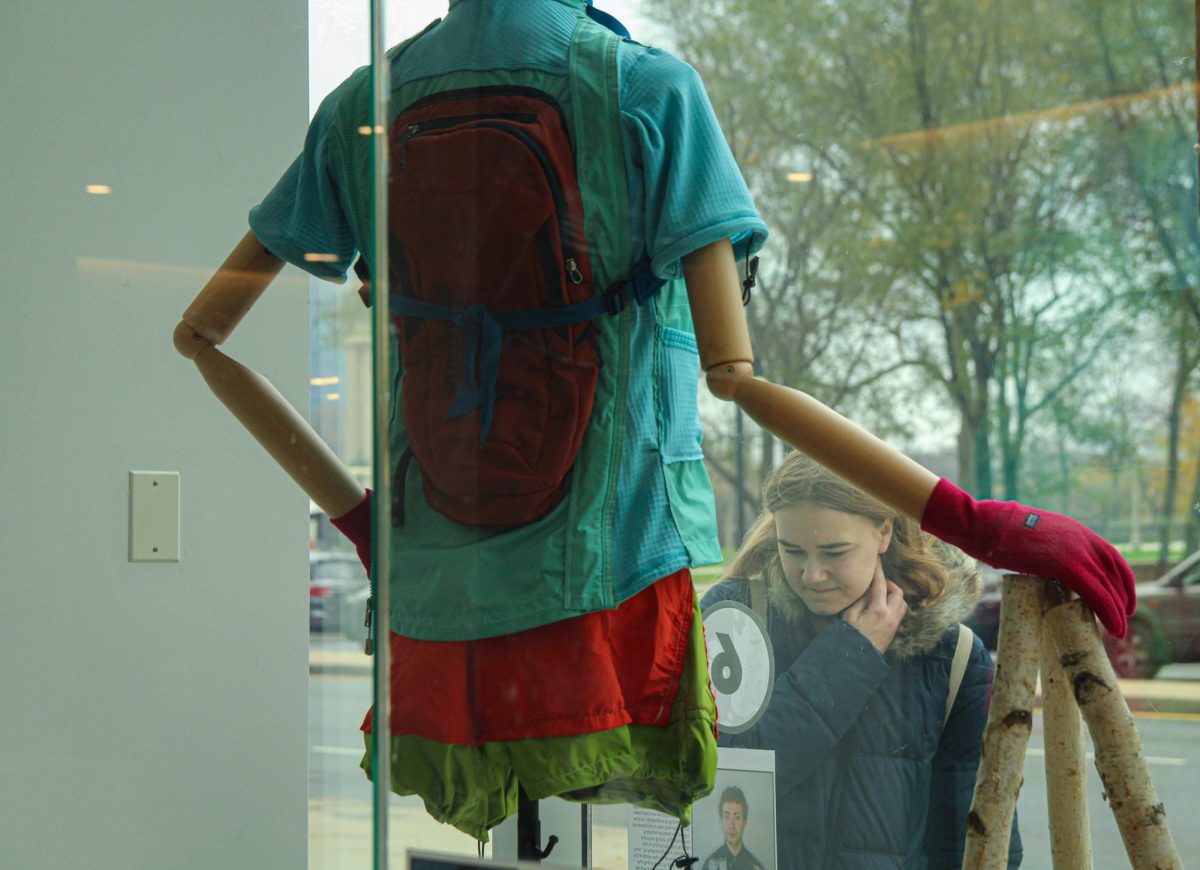 A student reading the description of the Patagonia design by fashion major, LJ Barnett outside 600 S. Michigan Ave. on Monday, Nov. 25, 2024. 