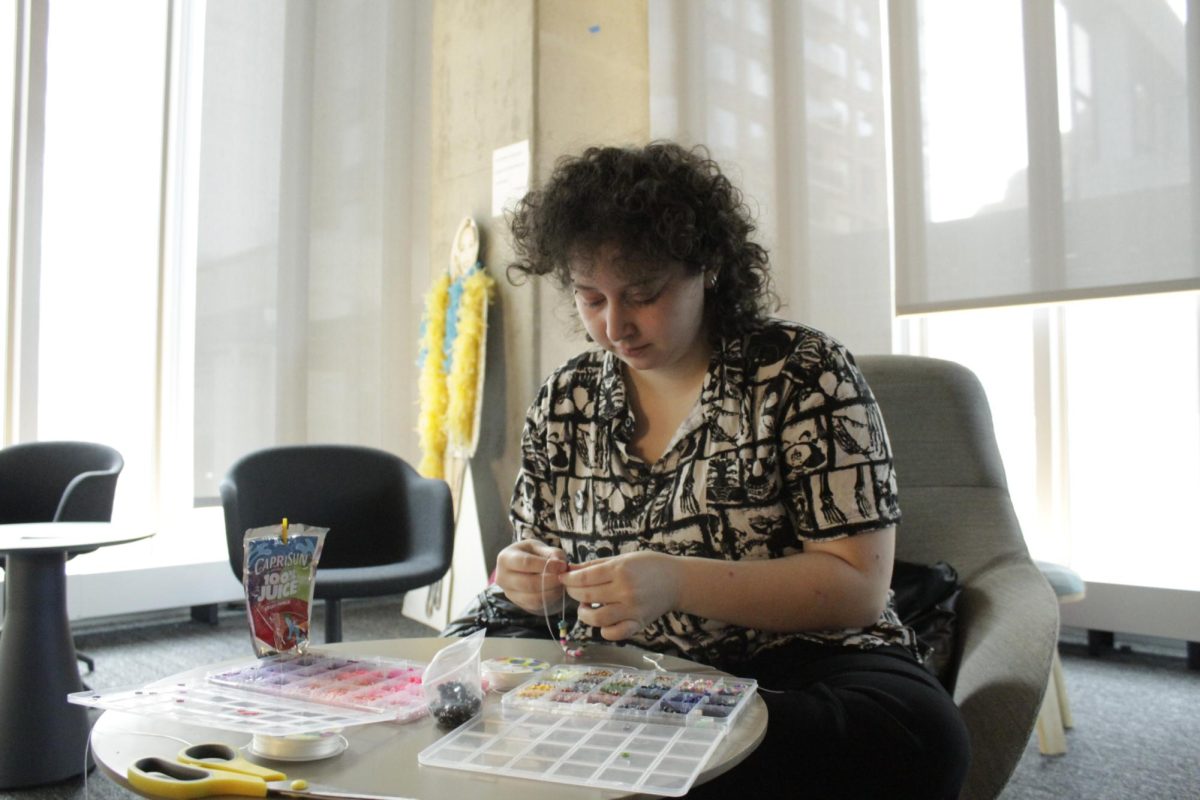 During the Winter Destressland event, Millea Lessin, a first-year acting major, makes a bracelet for themselves and their friends on Dec 3, 2024. 