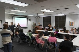 Diana Gorman Jamrozik, associate director of the School of Communication and Culture, speaks to students about what to expect during Campus Connections at 33 E. Ida B. Wells on Friday, Sep. 1, 2024.  ASL-English Interpretation major Quinn Bankler, who graduated in May 2024, interprets as Jamrozik speaks. The ASL-English Interpretation major is expected to be eliminated, although current students can continue until graduation.