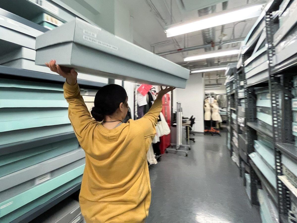 Anya Tapley, a student intern at the Fashion Study Collection, carries a box containing the FSC's oldest article: a nightgown from the 1810s, September 27, 2024 in Chicago, Illinois.