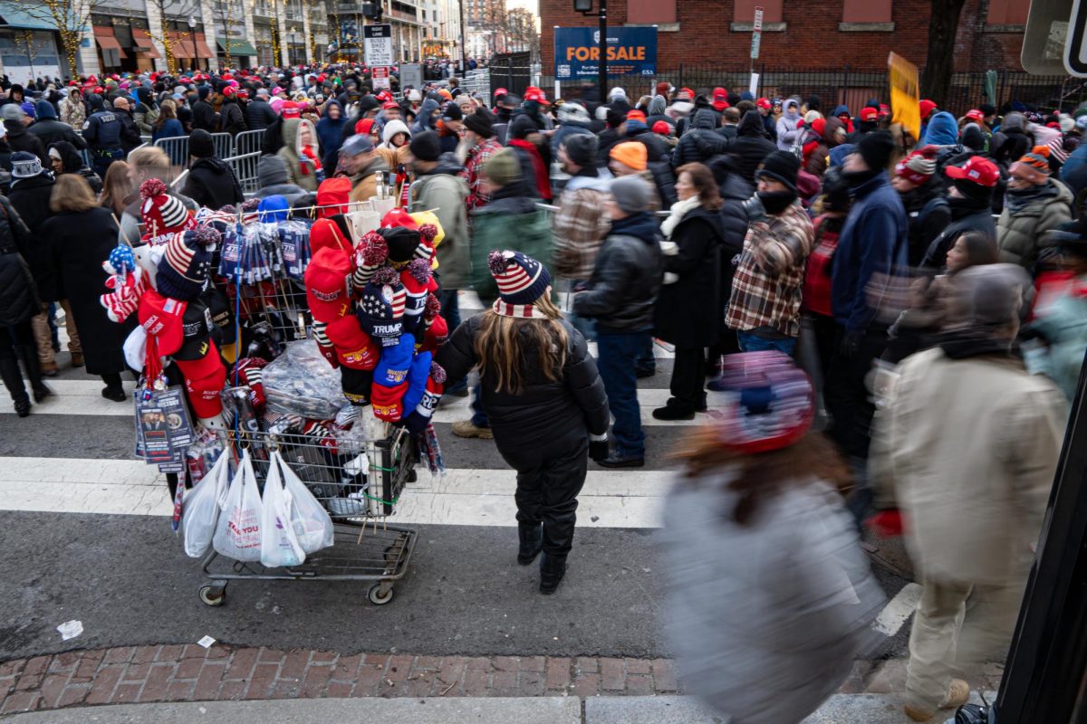 A vendor selling MAGA gear stands outside of the Capital One Arena in Washington D.C. as people stand in line for an inauguration watch party on Monday, Jan. 20, 2025. 