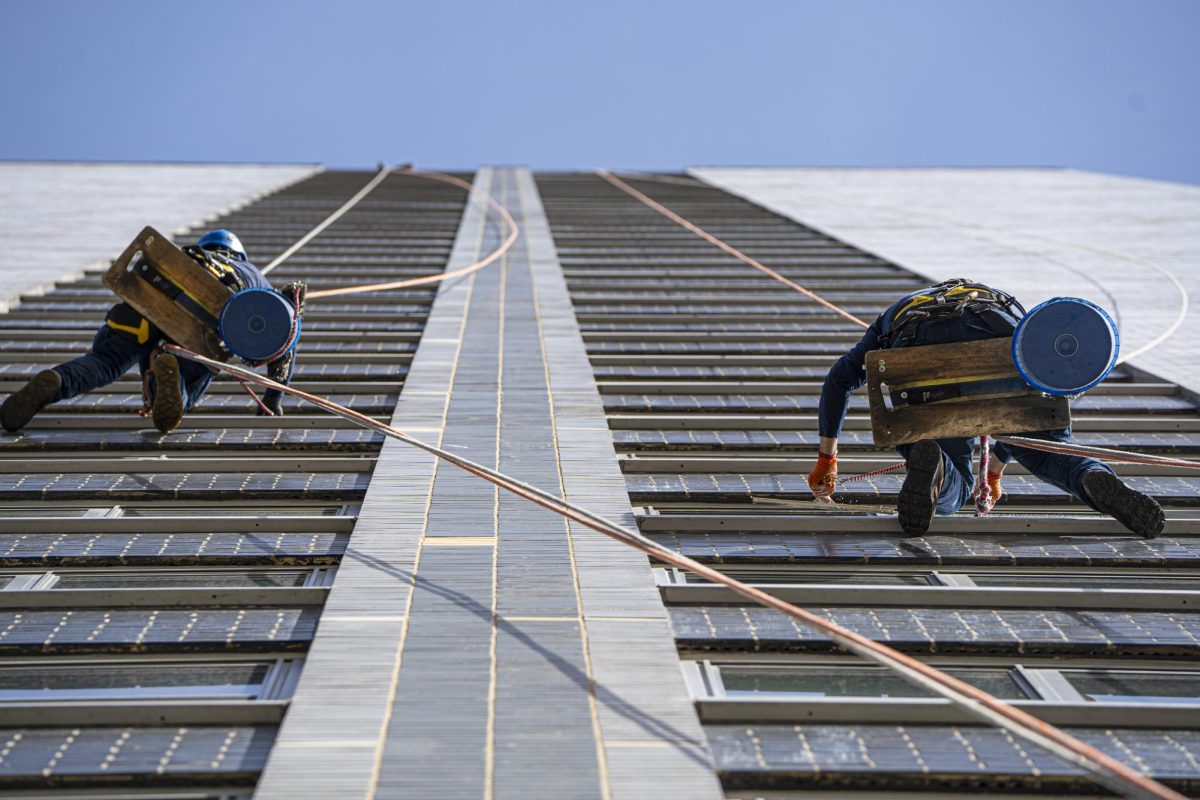 Two window washers clean as they make their way down a high rise located at 400 E. Randolph St. on Tuesday, March 11, 2025.