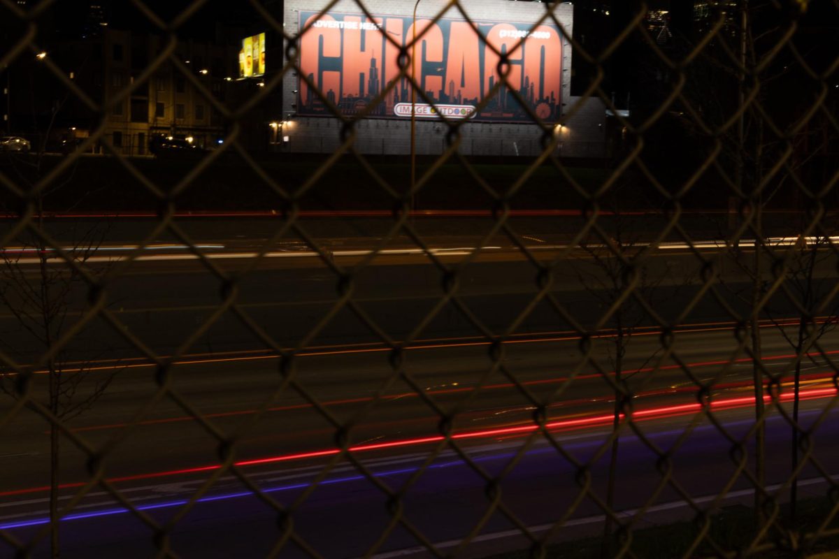 A long exposure taken through a fence of cars driving on the I-90/94 Kennedy Expressway on Wednesday, April 16, 2025.
