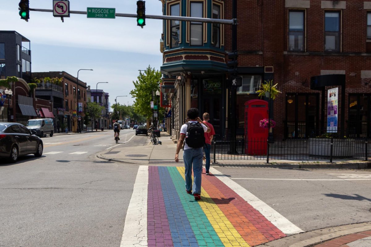 People walk across a rainbow crosswalk by a popular gay bar, Roscoe's Tavern, on North Halsted street in Chicago's Lake View East neighborhood on Monday, June 16, 2025.
