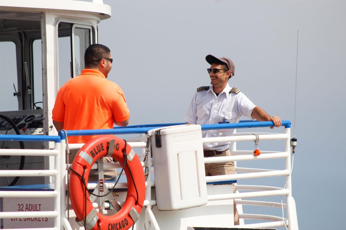 Captain Efraia Lopez talks to his coworker in-between boat rides on the Shoreline Sightseeing boat, which takes people on a tour route by the Chicago Lakefront, on Wednesday, June 25, 2025.