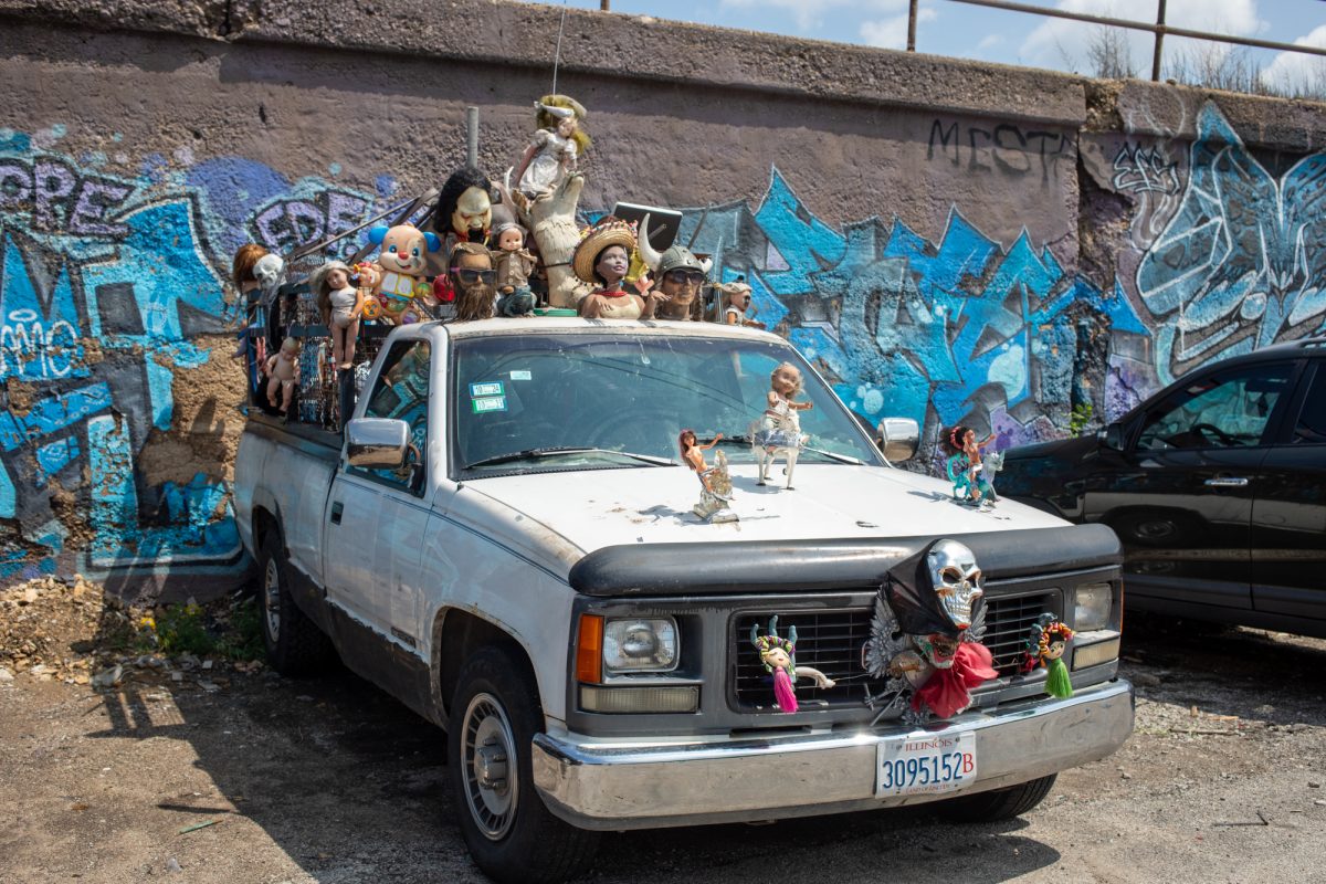 Junk yard car adorned with old children's toys and masks sits on 16th St. in Pilsen on Thursday, June 19, 2025. 