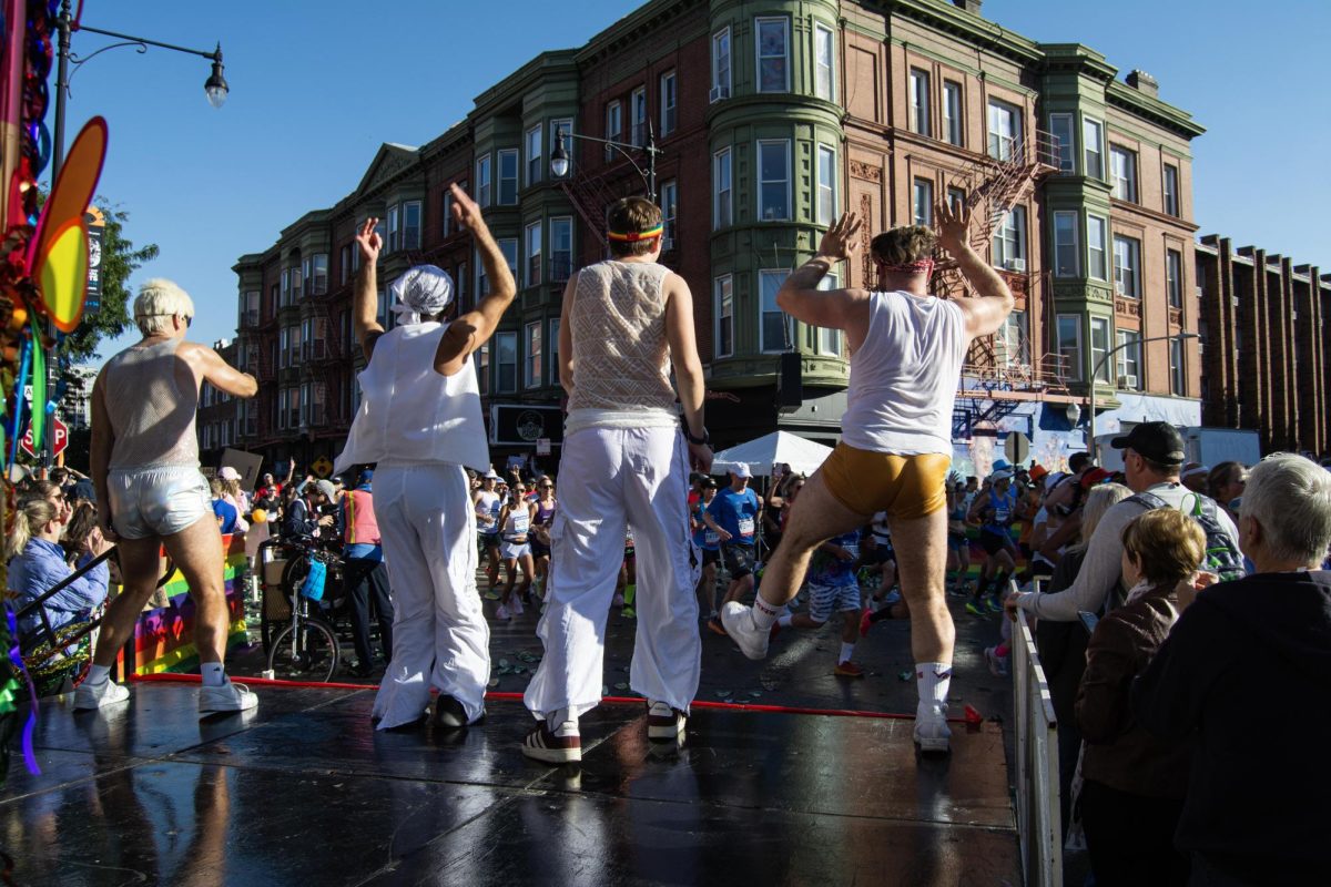 Members of Frontrunners/Frontwalkers, a Chicago running and walking club for members of the LGBTQ+ community, dance onstage at the mile eight "cheer zone" at the Bank of America Chicago Marathon on Sunday, Oct. 12, 2025.