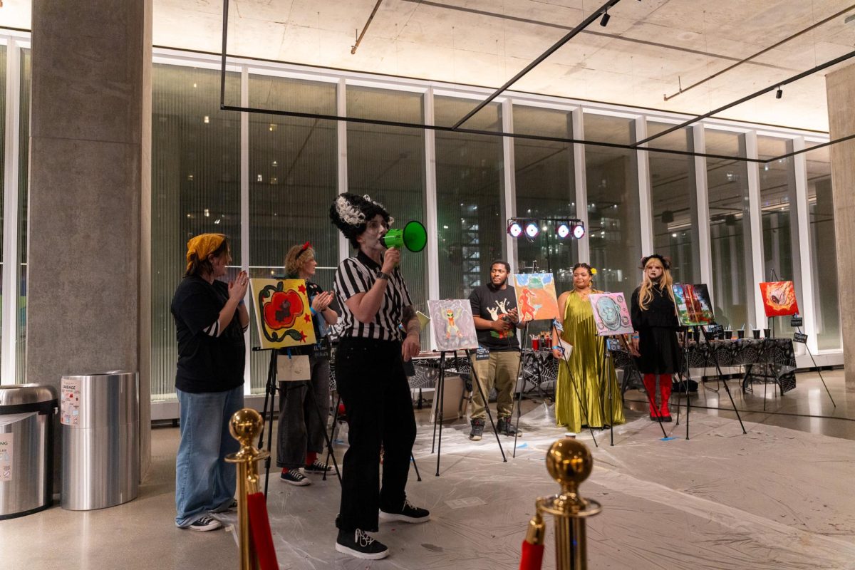 Cheri Charlton, assistant professor in the School of Visual Arts, announces the winner of the second round of the art battle as part of the Arts in the Dark Afterparty at the Student Center on Saturday, Oct. 18, 2025. 