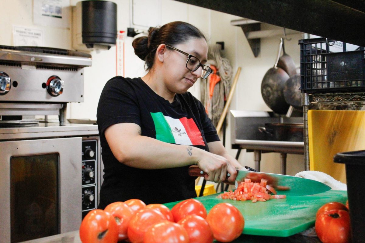 Carla Mayor chops tomatoes for Flaco's Taco's classic dishes in the South Loop neighborhood of Chicago on Dec. 3, 2025.