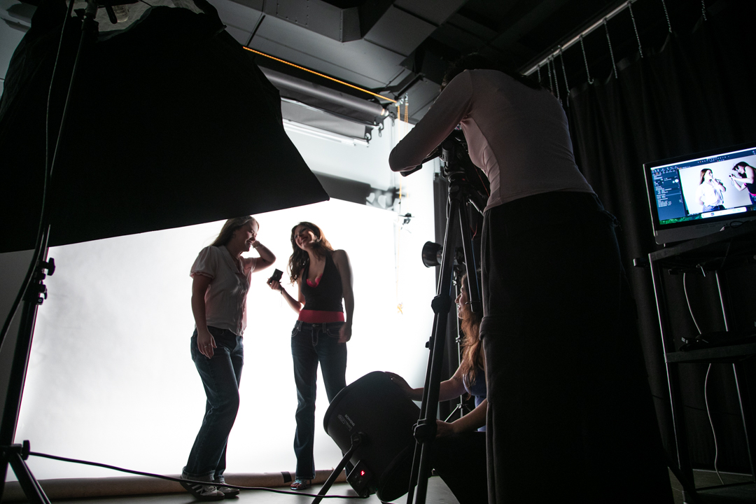 Valentina Agudelo, a sophomore marketing major, stands behind the camera and captures photos of her friends Ayla Weers and Ellie Hochevar while Stella McCullough works the wind machine in the photo studio on the second floor of 1104 S. Wabash Ave. on Friday, Dec. 5, 2025.