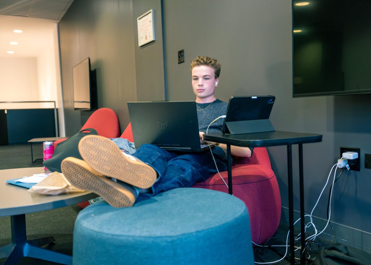 Joey Adamson, a sophomore interior architecture major with a minor in graphic design, takes a study break while seated on the second floor of the 618 S. Michigan Ave. building at Columbia College Chicago, overlooking Michigan Avenue on Tuesday, Feb. 10, 2026.
