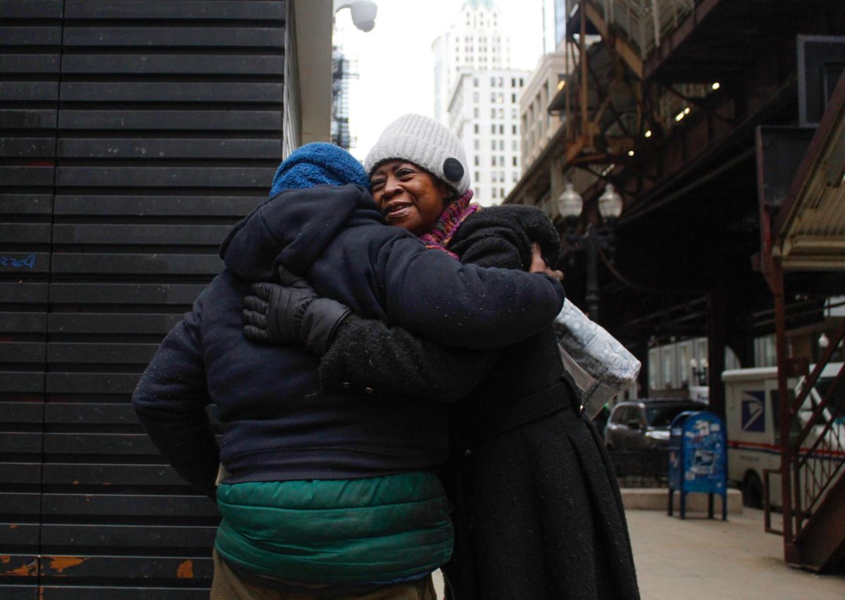 After recieving a compliment on her scarf, Aurelia Lawrence hugs Ismail Coleman at the Adams and Wabash intersection on Friday, Feb. 20, 2026. Chronicle photojournalist Sofía Oyarzún, a junior photojournalism and marketing major, won the ICPA's Ron Wiginton Photo Contest with this entry. The photographers were asked to shoot with the prompt "city block." Oyarzún is a photojournalist for the Chronicle and the La Cronica section editor this semester.