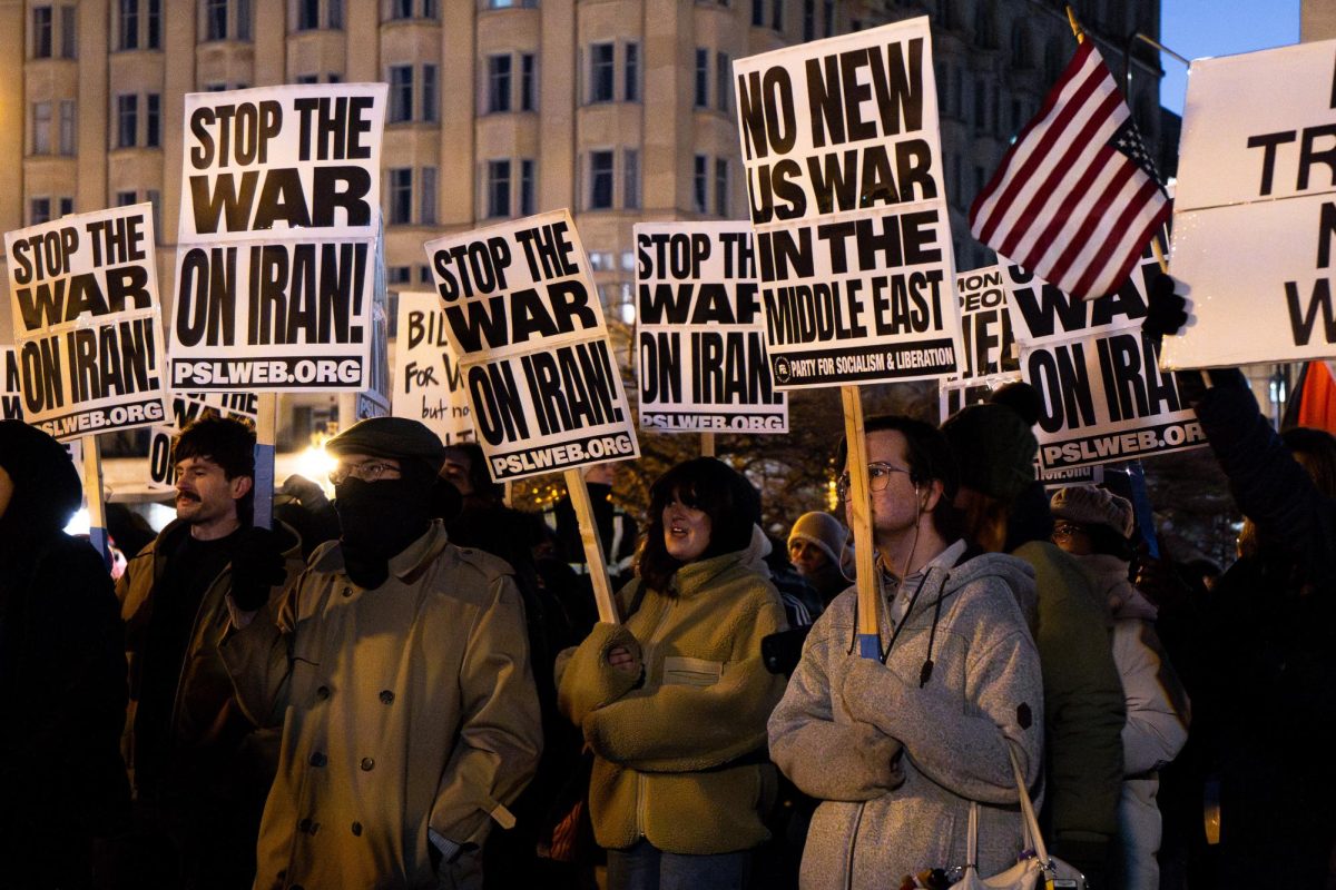 Demonstrators hold signs reading “Stop the War on Iran” at a protest in Congress Plaza on Monday, March 2, 2026.