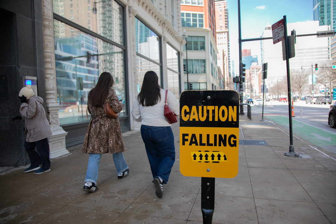 A warning sign for falling ice stands outside the 1104 S. Wabash building on Tuesday, March 17, 2026. Temperatures have dropped to below freezing following heavy rainfall and snow storms over the weekend into Monday. 
