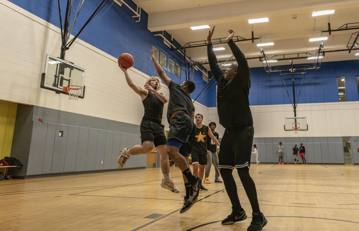 Students try to score a point against staff at the basketball game in the East-West University gym on Wednesday, April 29, 2026.