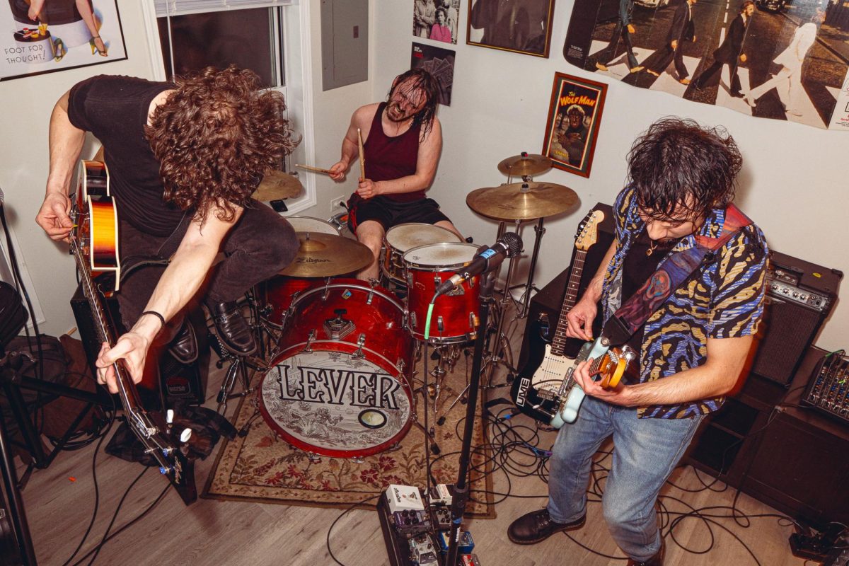 The bassist of the band Lever (left) jumps during the chorus of one of their songs during a house show in Chinatown on Friday, April 10, 2026.  