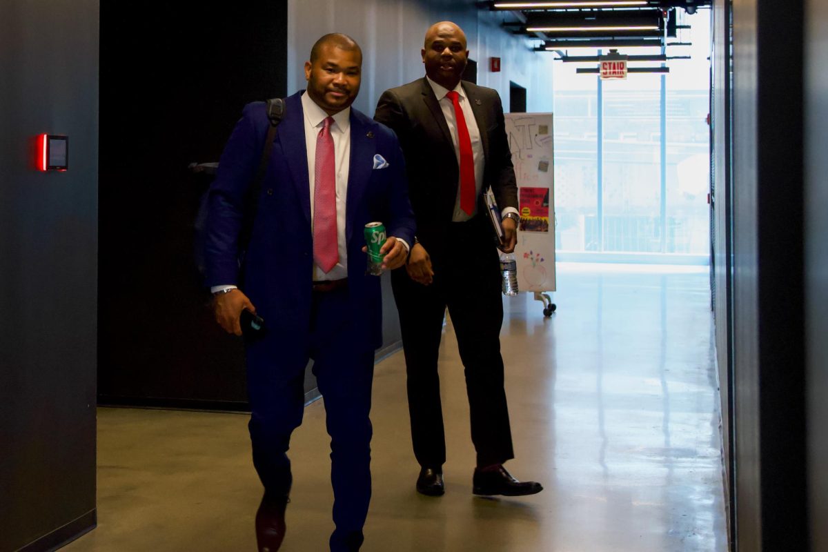 Adriel Hilton, the college’s vice president of institutional strategy and chief of staff, exits the boardroom at the Student Center with Senior Vice President for Enrollment Strategy and Student Success Emmanuel Lalande on Wednesday, May 6, 2026.