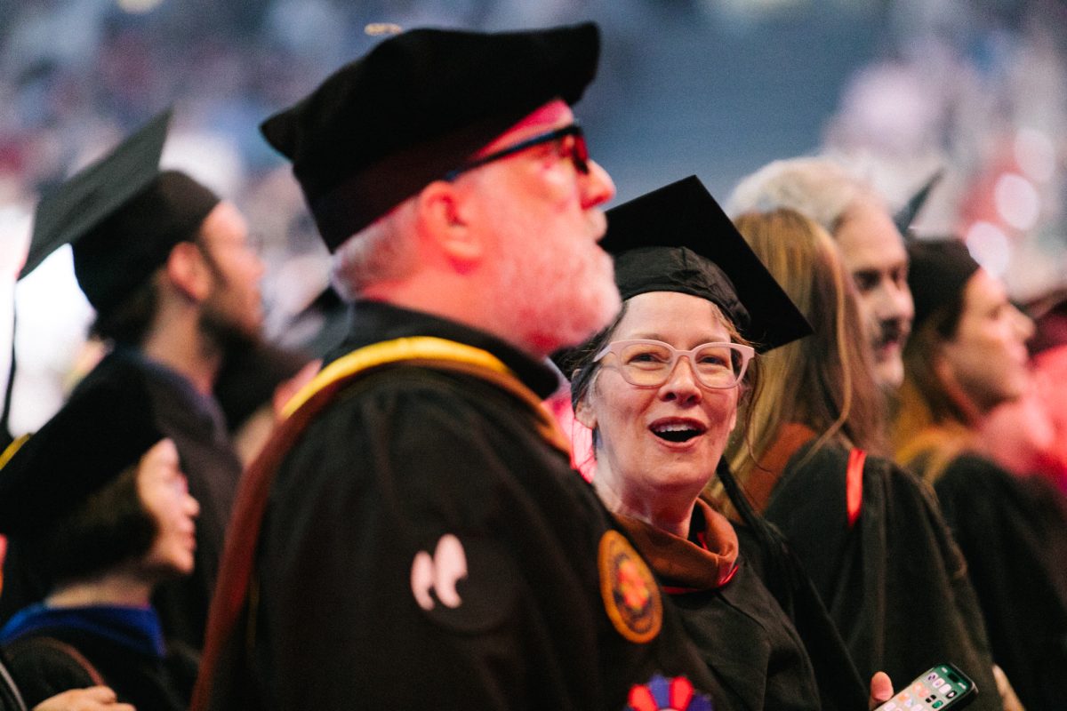 Alison Carey, an associate professor, looks on as graduates make their way to their seats at the Credit Union 1 Arena on Sunday, May 17, 2026.