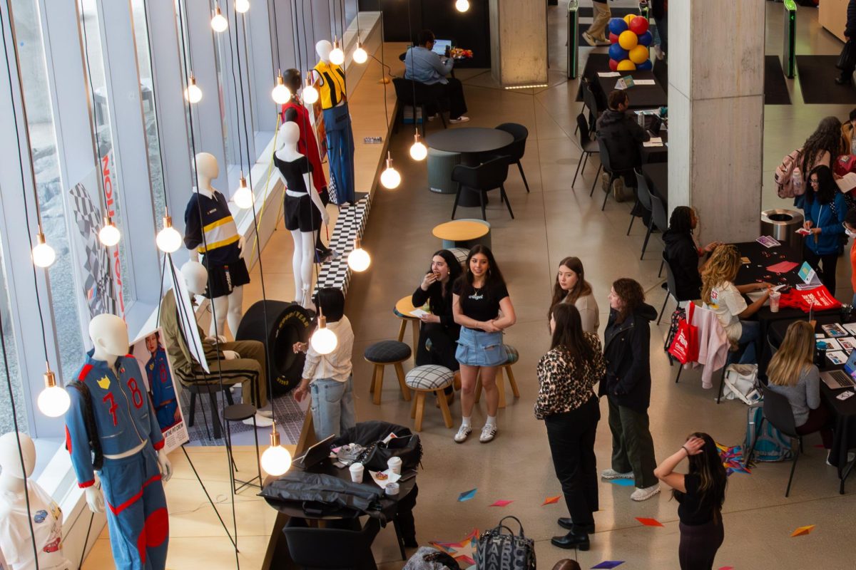 Students take a look at the NASCAR Collection from the Fashion Senior Capstone Display installed in the Student Center on Tuesday, May 12, 2026.