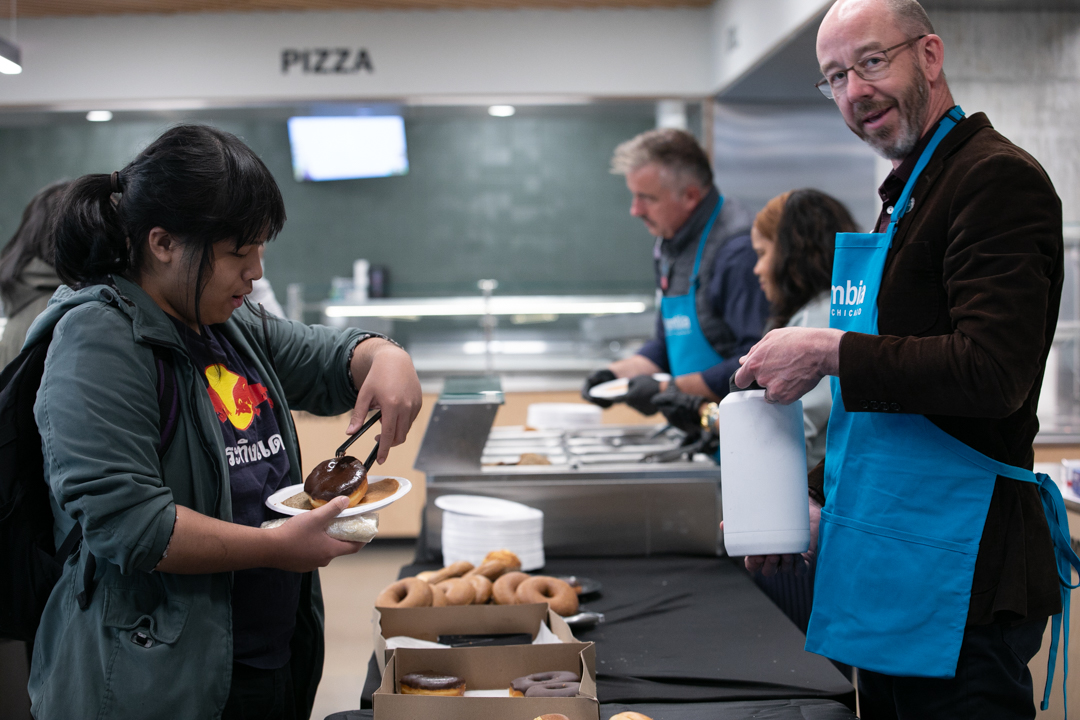 Allen Santisouk, a junior musical theatre major, retrieves a doughnut and places it on a paper plate, as Senior Associate Provost Nathan Bakkum assists by carrying Allen's water bottle during the President's Student Appreciation Brunch on Monday, May 11, 2026.