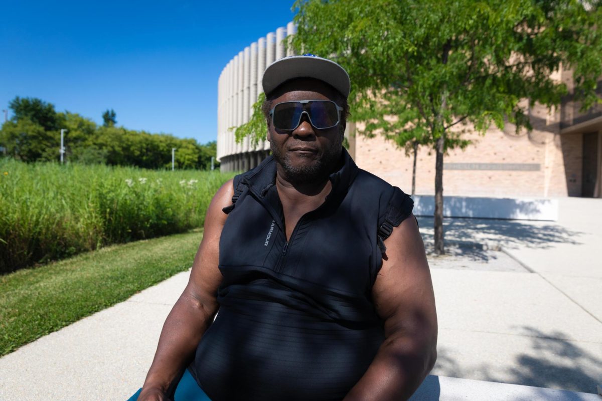 Larry Johnson relaxes in the shade on a concrete bench at the Brighton Park Community Campus on Thursday, June 25, 2026. Johnson frequently visits the campus, located on Chicago's Southwest Side, to work out outdoors. This photo is part of the Columbia Chronicle’s “77 Community Areas” project, documenting Chicago ahead of America’s 250th birthday.