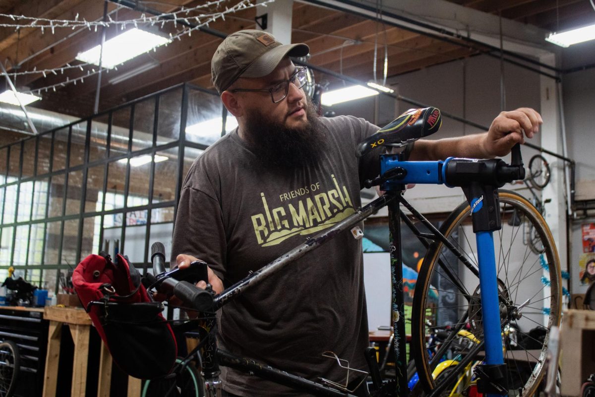 Program coordinator Francisco Rubio works on bikes at the Bikes N' Roses shop in Hermosa on Monday, June 29, 2026. The shop runs under the Communities United program and collaborates with After School Matters for youth to come build and purchase bikes. This photo is part of the Columbia Chronicle's "77 Community Areas" project, documenting Chicago ahead of America’s 250th birthday.