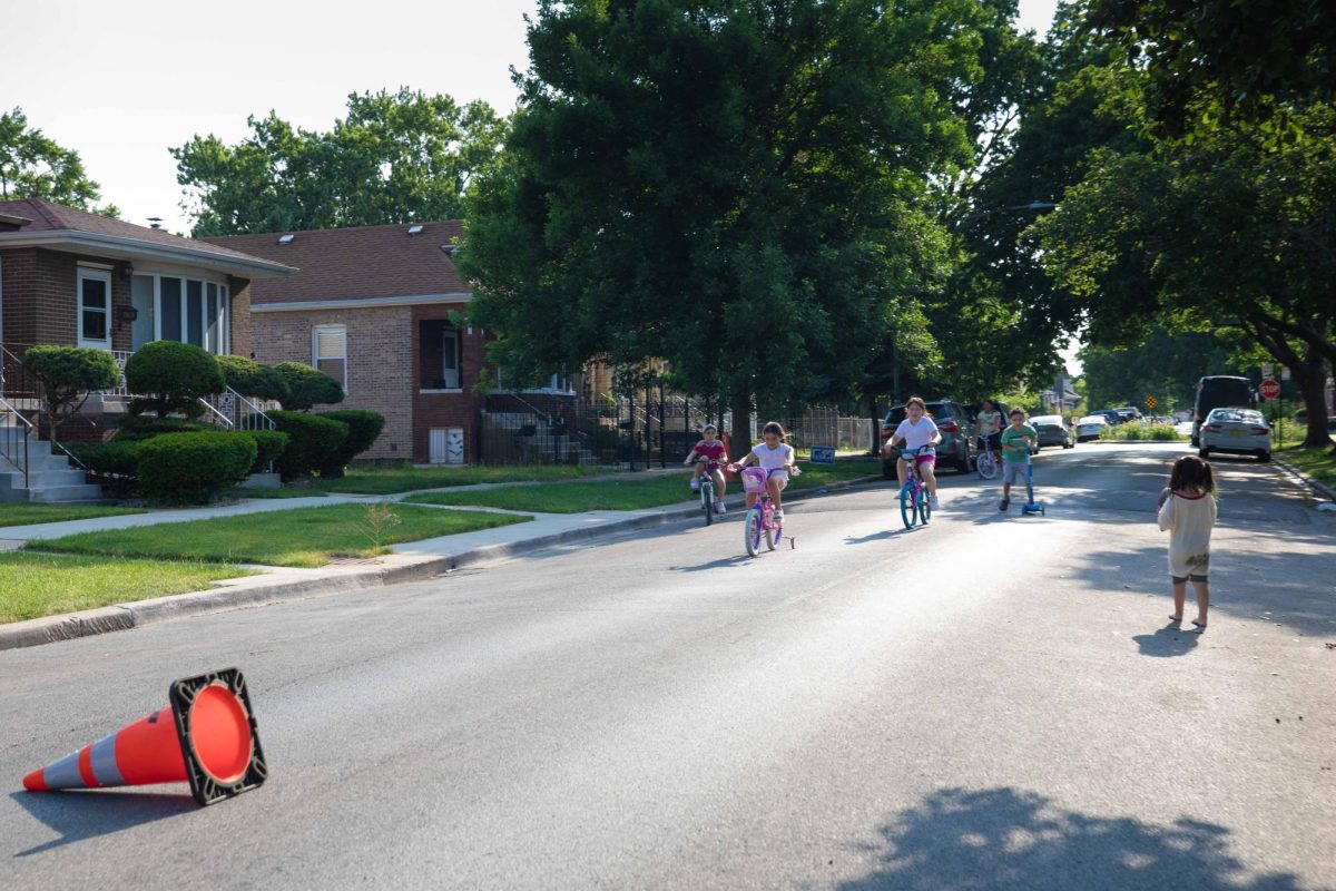 Children ride down 61st Street near Hamlin Avenue during a neighborhood block party in the West Lawn neighborhood. West Lawn is a neighborhood on the Southwest Side of Chicago. This photo is part of the Columbia Chronicle’s “77 Community Areas” project, documenting Chicago ahead of America’s 250th birthday.