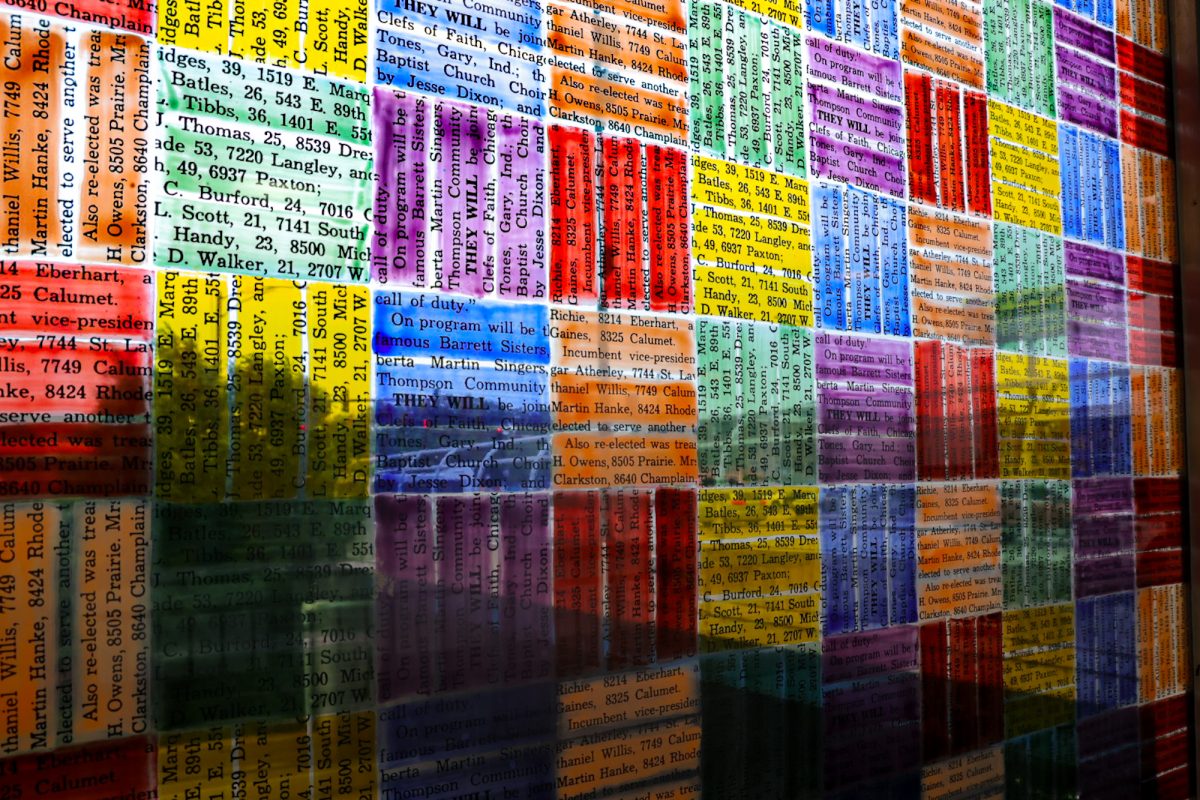 Stained glass glistens with archival text at the 79th Red Line stop in Chicago's Chatham neighborhood on Monday, July 20, 2026. The text was originally published in the Chatham Citizen newspaper on June 16, 1965, and was reproduced on stained glass by artist McArthur Binion in 2015. This photo is part of the Columbia Chronicle's "77 Community Areas" project, documenting Chicago in celebration of America’s 250th birthday.