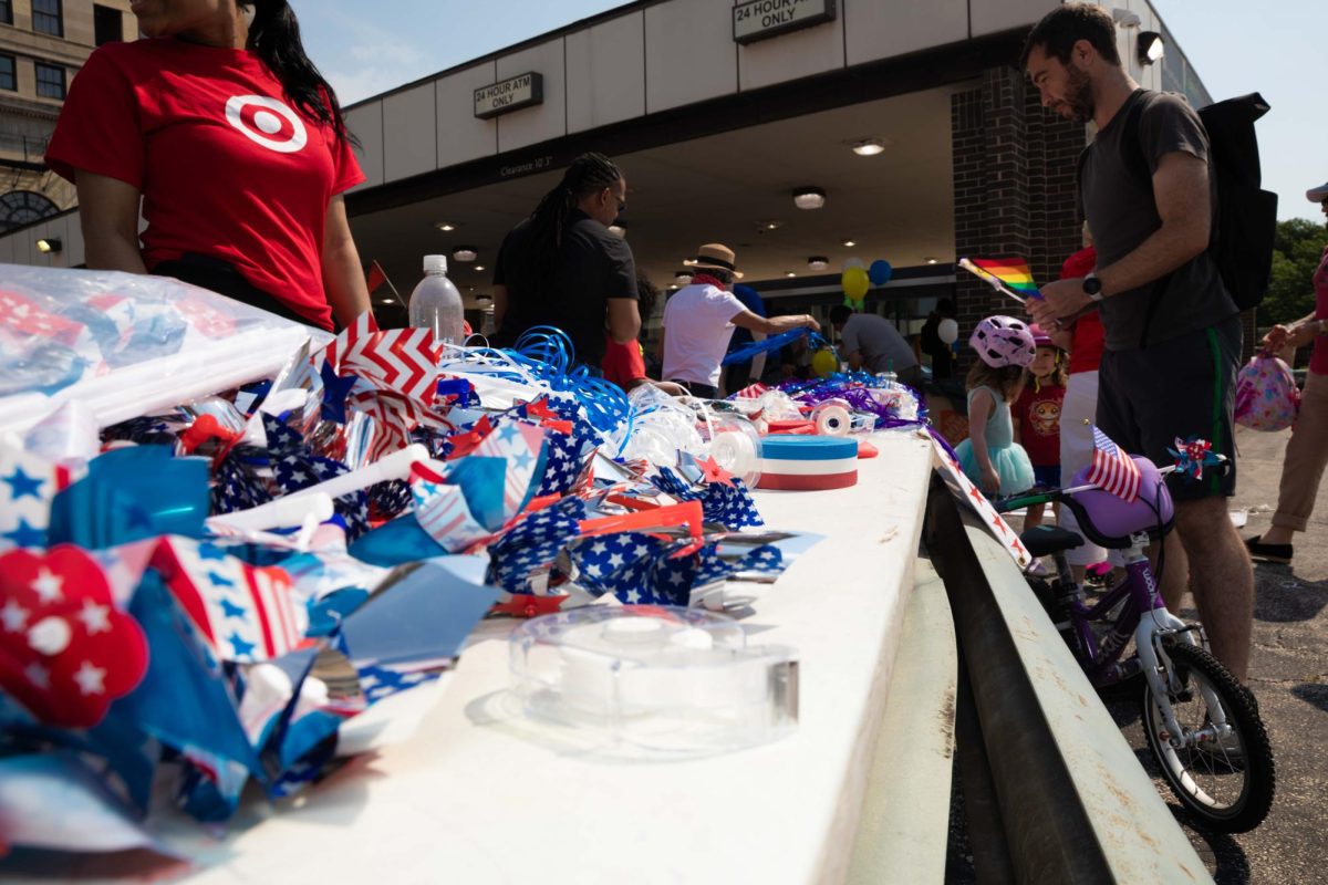 Participants gather around a community table to decorate their bikes, organized by The Bike Brigade on Saturday, July 4, 2026.