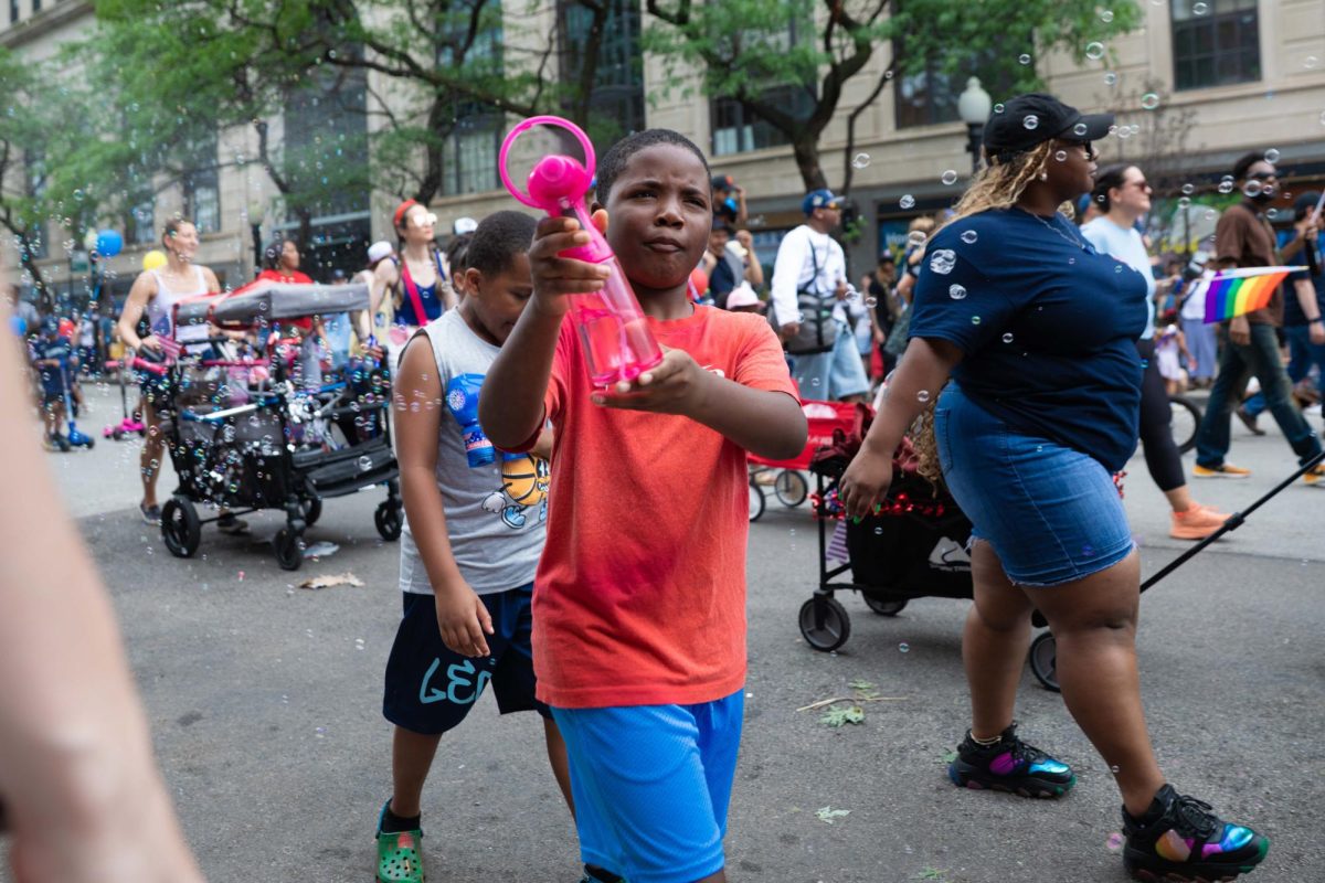 A young parade participant uses a handheld water sprayer to cool down attendees along 53rd Street during the annual 4th on 53rd Parade in Chicago’s Hyde Park neighborhood, Saturday, July 4, 2026.