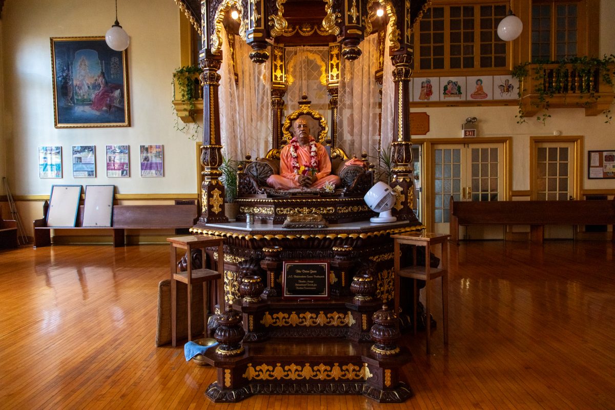 A statue of A. C. Bhaktivedanta Swami Prabhupada, a spiritual teacher and founder of the International Society for Krishna Consciousness, sits in the sacred space of the ISKCON center in the Rogers Park neighborhood on Tuesday, July 21, 2026. Formerly a Masonic lodge built in 1910, the building was purchased by the Hare Krishna congregation in 1973 and converted into a temple. This photo is part of the Columbia Chronicle’s “77 Community Areas” project, documenting Chicago in celebration of America’s 250th birthday.