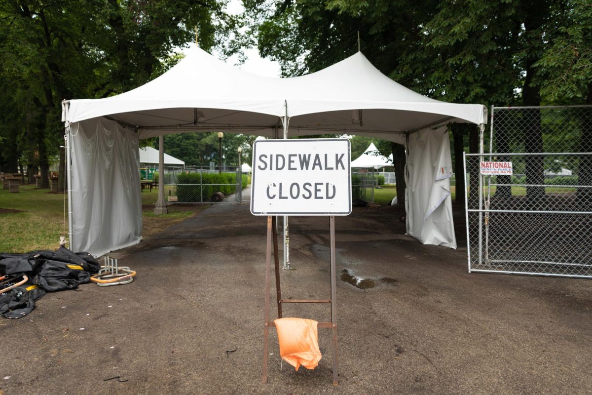 A sign reading “sidewalk closed” stands at the entrance of a security tent during the post-festival teardown for Lollapalooza in Grant Park on Wednesday, Aug. 5, 2026. Portions of the park remain blocked off to the public while crews dismantle security fencing, tents and staging infrastructure.