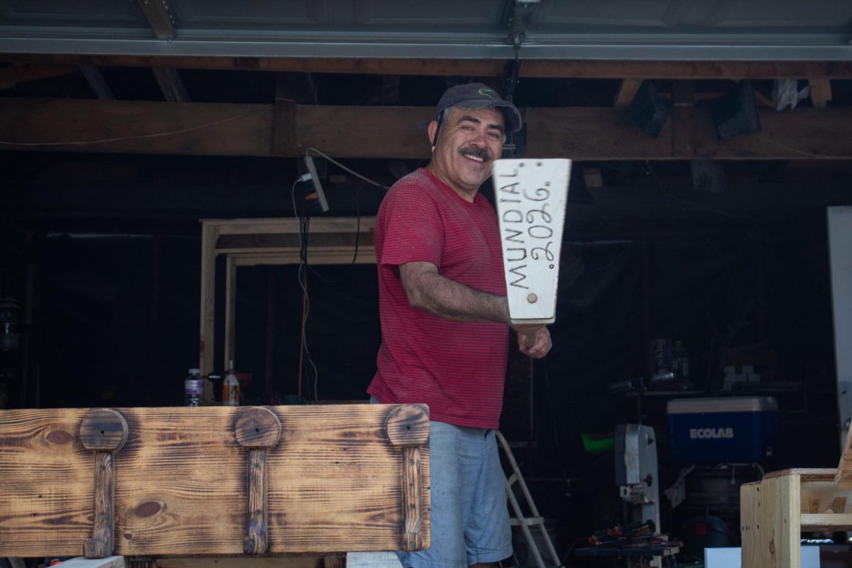 Gregorio Castillo shows off celebratory woodwork used to celebrate the World Cup in Portage Park on Friday, Aug. 7, 2026. For five years, he has sold handmade woodwork out of his garage for community members to purchase. This photo is part of the Columbia Chronicle’s “77 Community Areas” project, documenting Chicago in celebration of America’s 250th birthday.