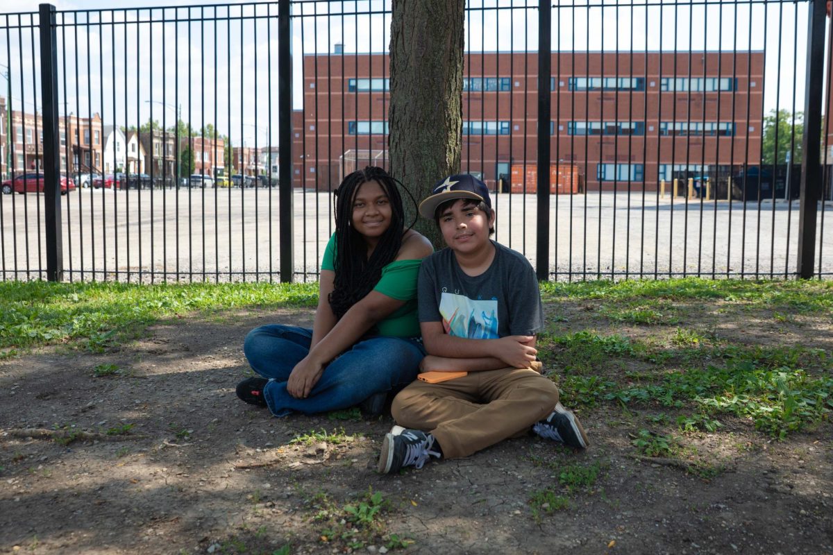 Karen Rollins, a lifelong resident of Avondale, poses for a portrait with Logan Abdala, who’s lived in the neighborhood for one year, at the Avondale Public School soccer field on Tuesday, Aug. 4, 2026. This photo is part of the Columbia Chronicle’s “77 Community Areas” project, documenting Chicago ahead of America’s 250th birthday.