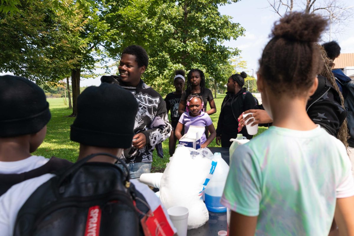 Youth affiliated with Latanya Youth of Englewood prepare a refreshment table to sell drinks to raise funds for technology at Ogden Park in the West Englewood neighborhood. This photo is part of the Columbia Chronicle’s “77 Community Areas” project, documenting Chicago in celebration of America’s 250th birthday.