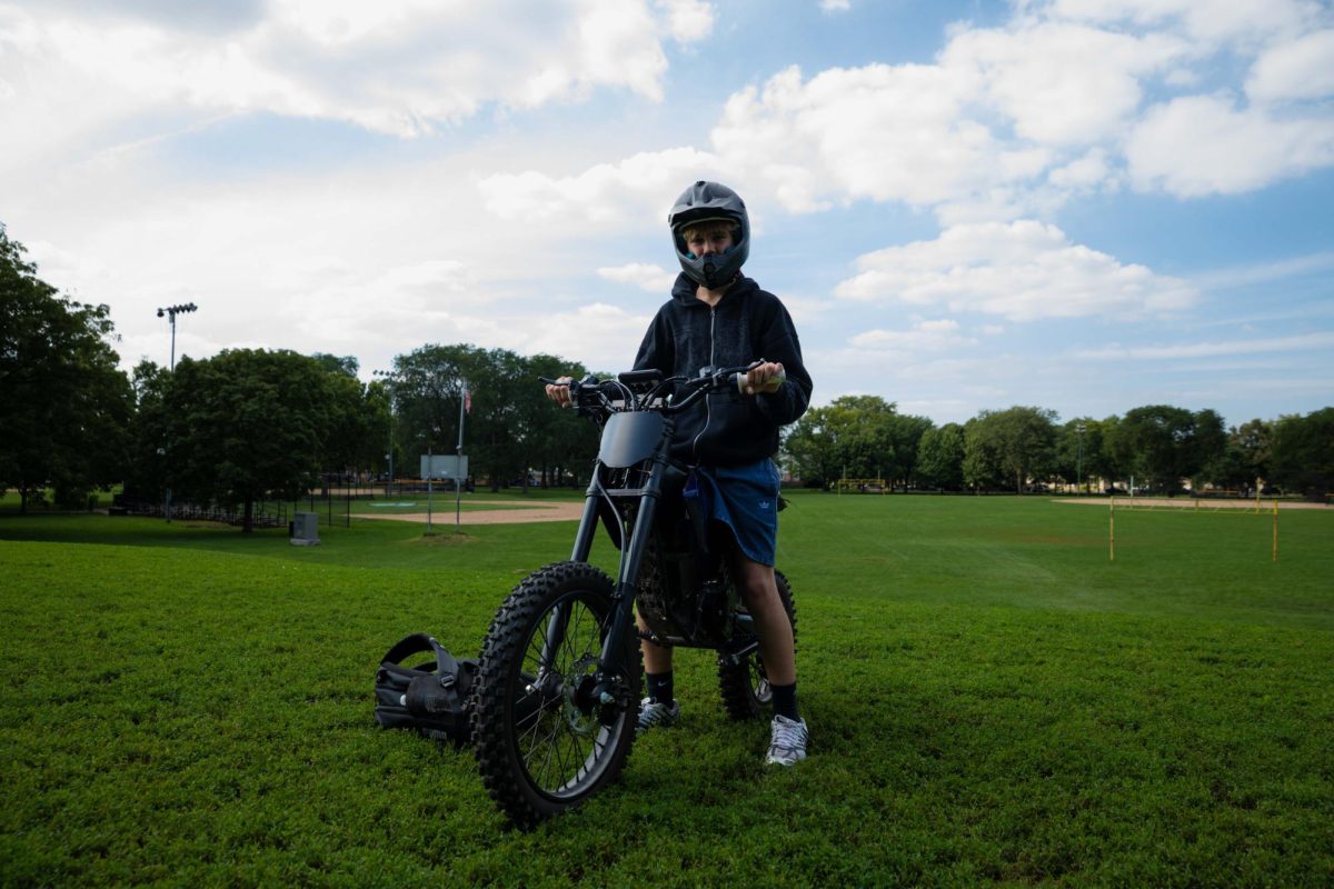 Denis Fedorchuk poses on an electric dirt bike at Oriole Park in the Norwood Park neighborhood on Wednesday, Aug. 26, 2026. This photo is part of the Columbia Chronicle’s “77 Community Areas” project, documenting Chicago in celebration of America’s 250th birthday.