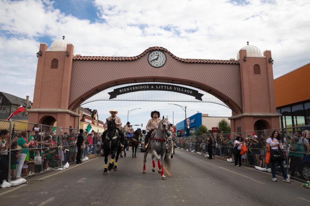 Jinetes a caballo cruzan bajo el icónico Arco de Little Village en la intersección de la calle 26 y la avenida Albany durante el inicio del 55.º Desfile del Día de la Independencia de México el domingo 13 de septiembre de 2026.