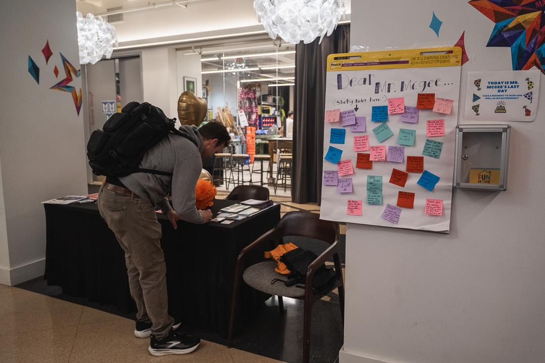 Assistant Professor of Instruction Colte Julian writes a farewell message to Melvin McGee on his final day as a campus security officer, at the Theatre Center, 71 E. 11th St., on Thursday, Oct. 1, 2026.
