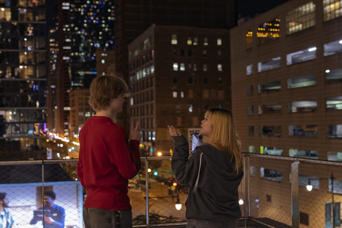 Justin Vik, a film and television major, and Jaides Su, a film and television major, try to take a selfie on the fourth floor balcony of the Student Center on Thursday, Oct. 29, 2026.